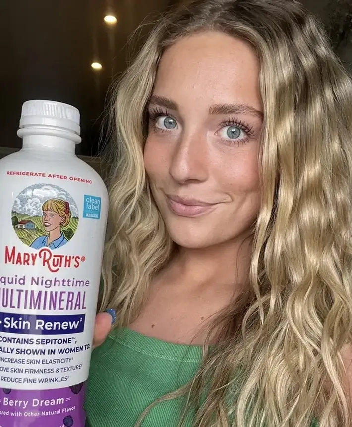 MaryRuth Organics creator holding a liquid multimineral bottle